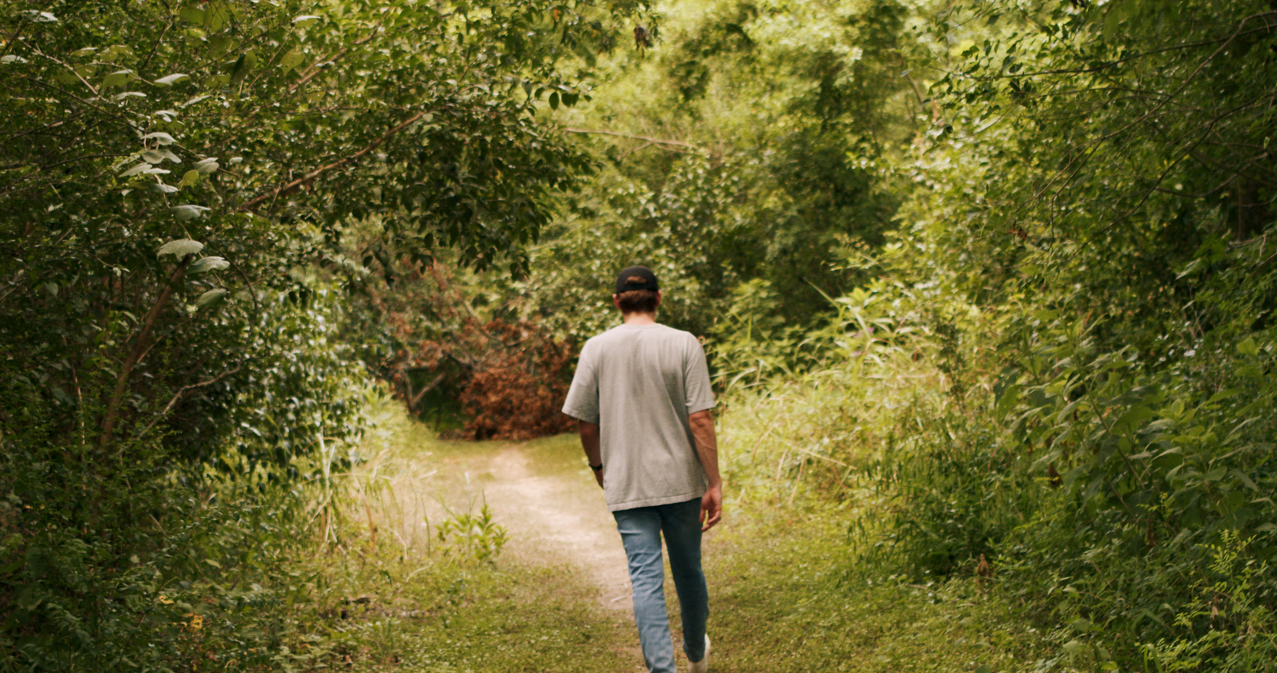 Dylan Gossett walking through wooded path in Buda TX